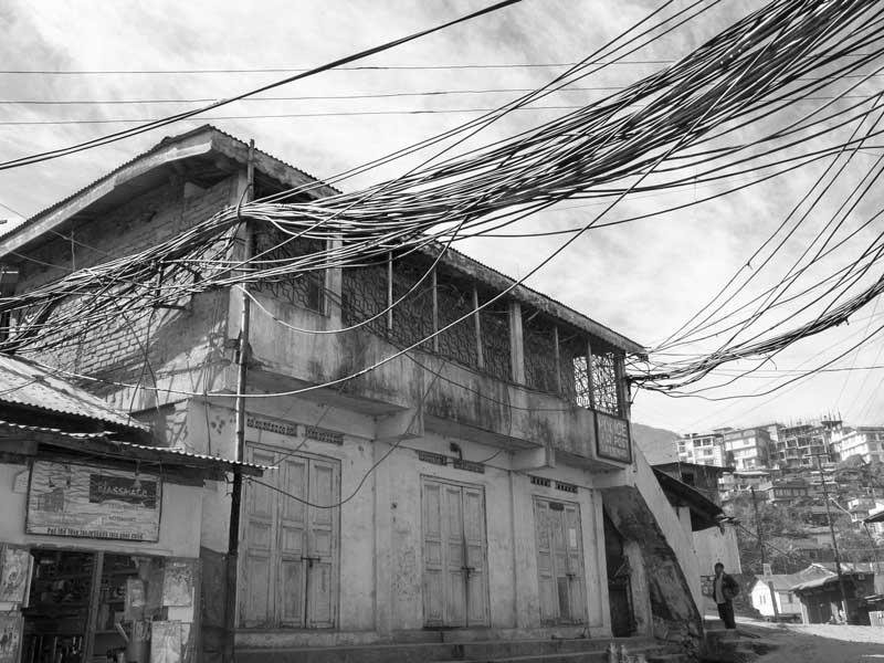Water cables bundled together and hanging untidily between buildings in Kohima, Nagaland, in the absence of any supporting infrastructure